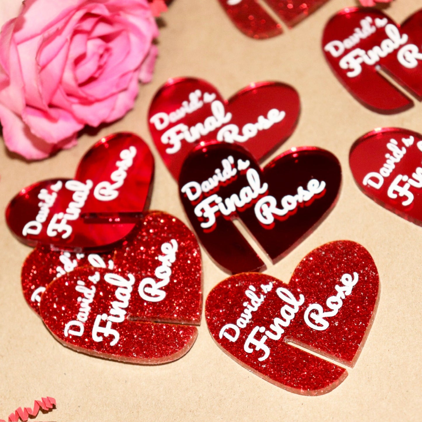 Close up of mirrored red and red glitter acrylic heart tags with “David’s final rose” engraved in white