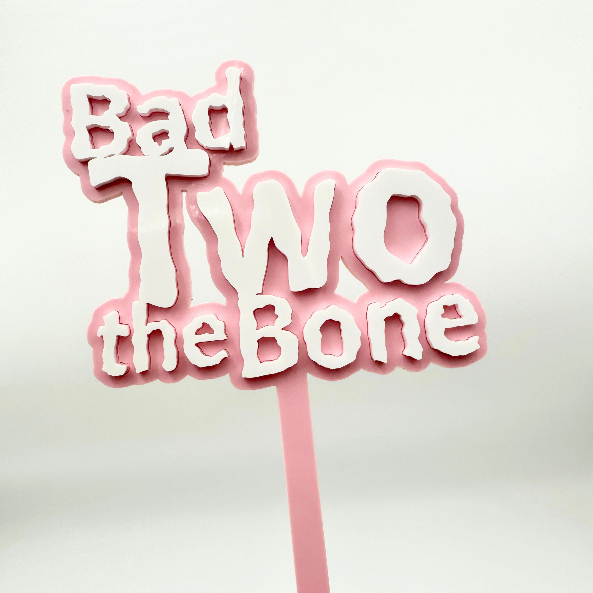 Pastel pink bad two the bone cake topper