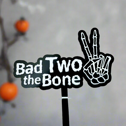 Close up of bad two the bone cake topper