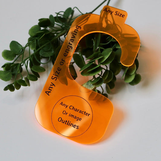 Neon orange acrylic closet divider on top of an artificial leafed stem to demonstrate it is translucent. Closet divider has engraved, “any size, any size or engraving, any character or image outlines” on it