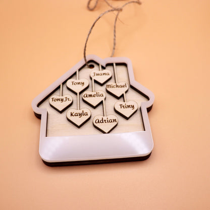 Lying down image of the White acrylic house ornament with 8 custom names on wooden hearts