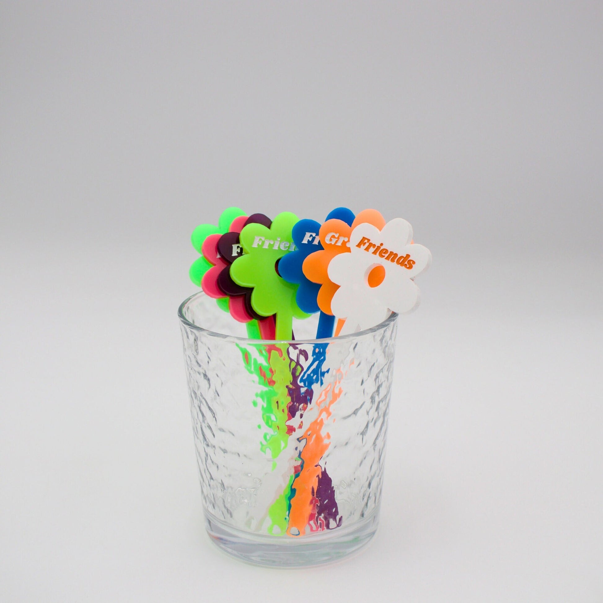 Assortment of neon drink stirrers in a cup