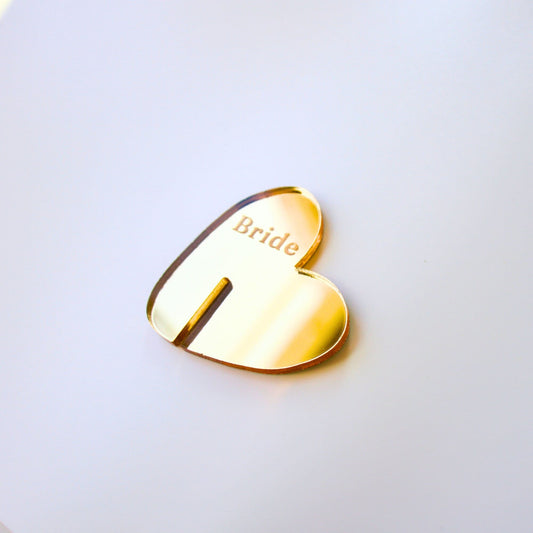 Close up of gold mirrored heart drink tag with “bride” engraved