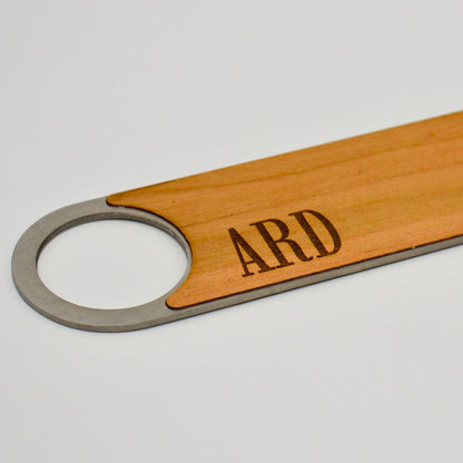 close up of monogram engraved onto wooden bottle opener