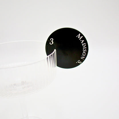 Close up of round drink tag featuring black pearl acrylic